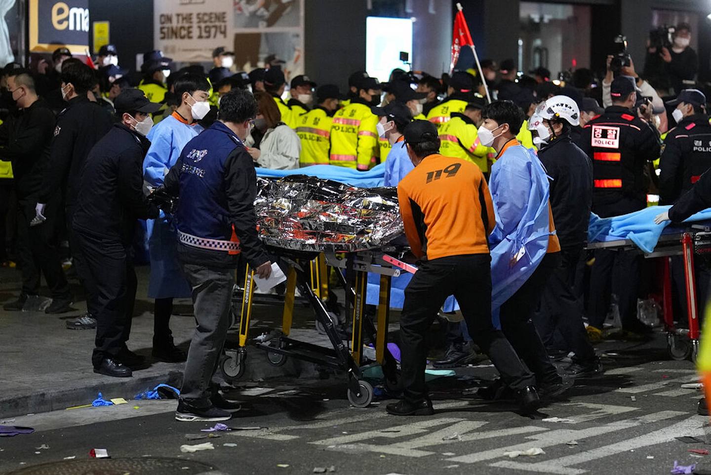 韓國梨泰院人踩人：圖為2022年10月29日踩踏事件發生後，救援人員移送一名傷者。（AP）
