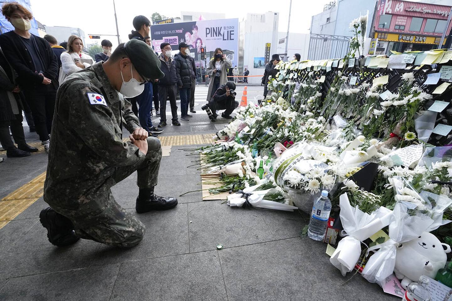韓國梨泰院人踩人：韓國首爾龍山區梨泰院洞2022年10月29日人晚發生踩踏事故，韓國一名軍人在案發後3天、即11月1日重回慘劇現場附近的街道悼念，單膝下跪致哀。（AP）