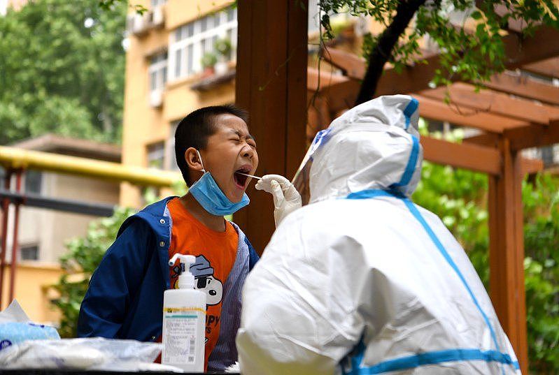图为河南省郑州医务人员为小朋友进行核酸采样。 新华社