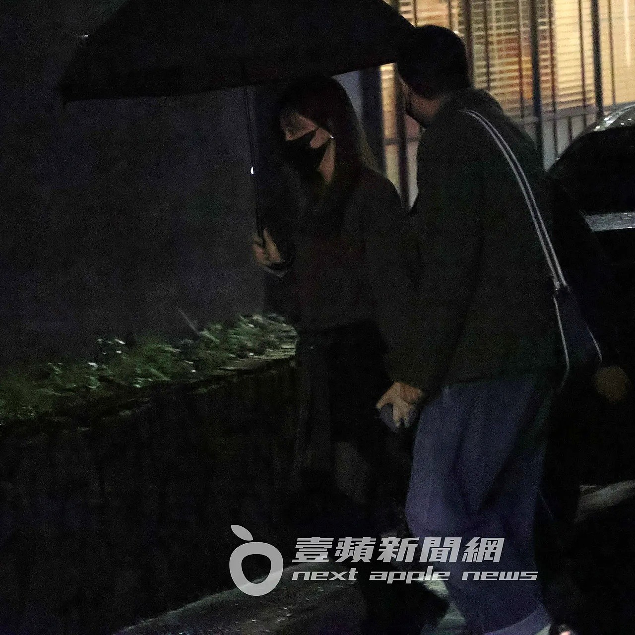 王心凌（左）撐著雨傘，走進中山區的餐酒館續攤。特勤中心攝