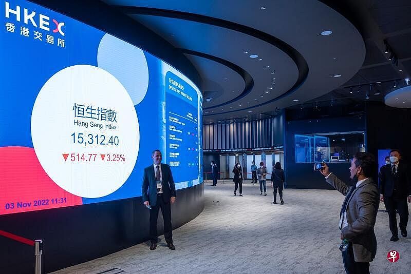 香港金融管理局本周举办国际金融领袖投资峰会，图为一名与会者在香港联通大厅的屏幕前拍照。（彭博社）