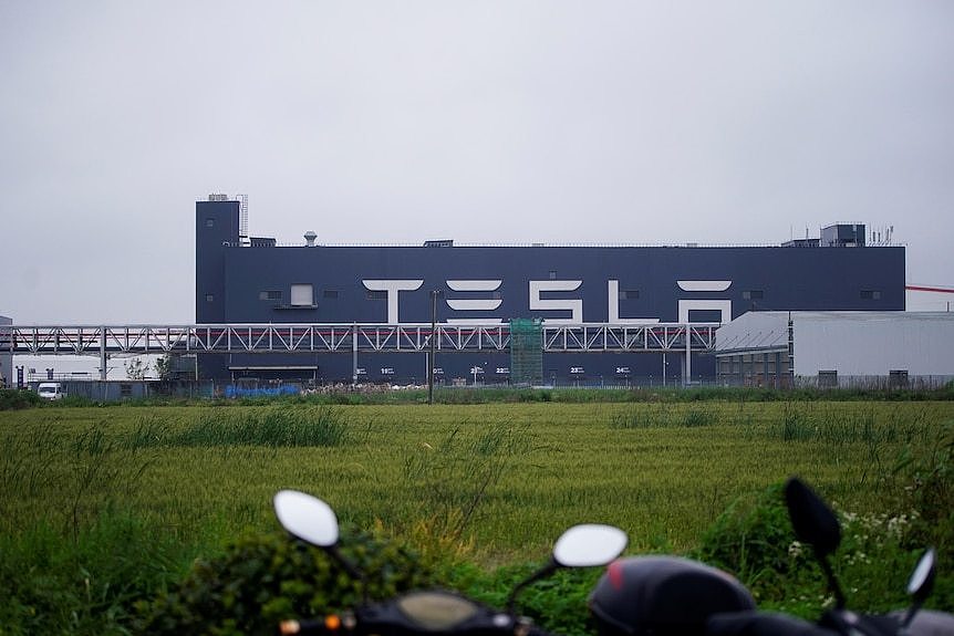 一座写有特斯拉英文标识的厂房矗立在上海的郊区。