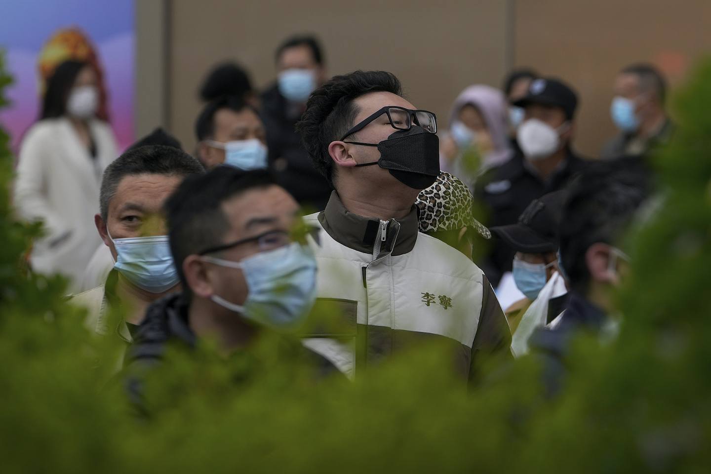 一名戴着口罩的男子在北京一家病毒检测点排队等候取咽拭子。 （美联社照片/安迪黄）