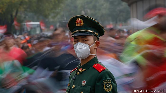 2022年北京马拉松比赛现场的武警士兵和身后的民众