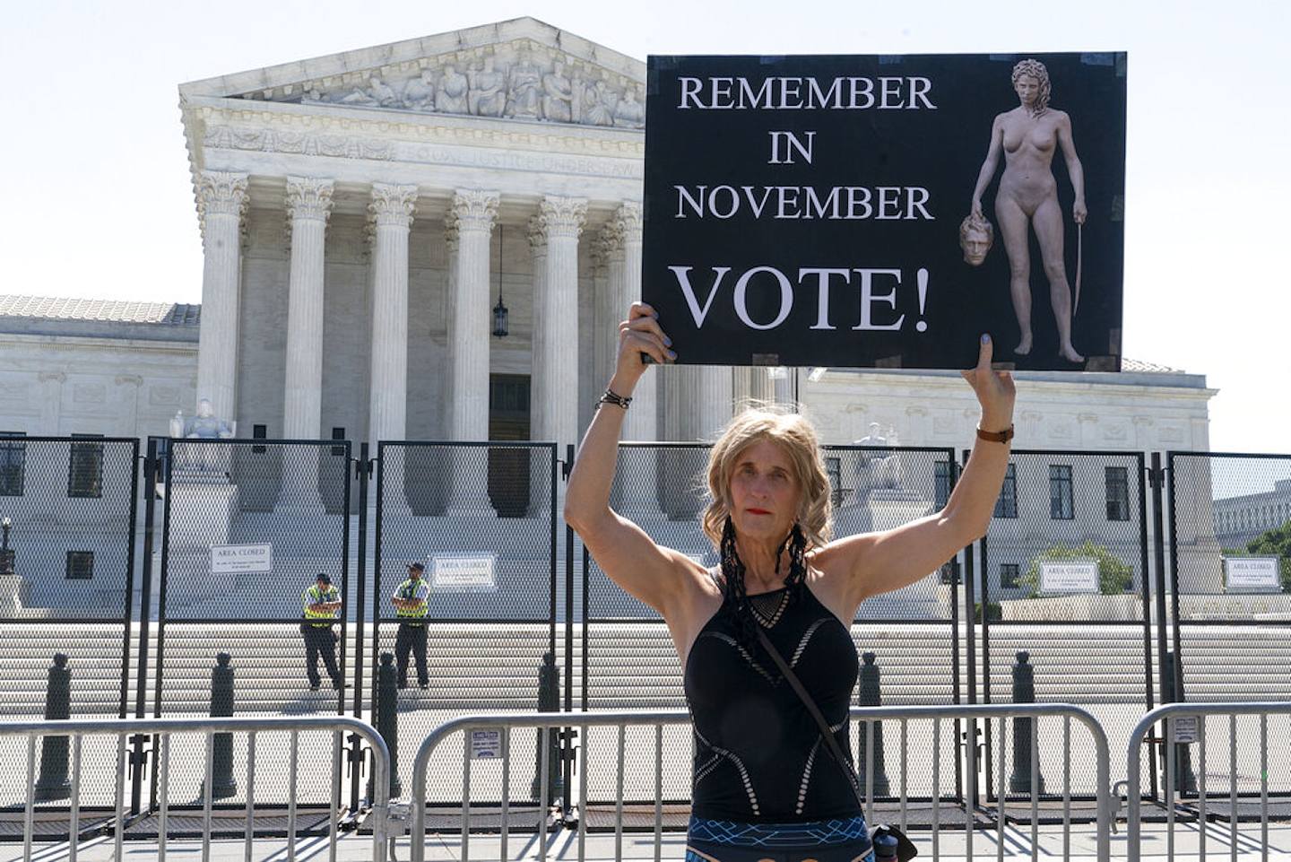 美國中期選舉：圖為2022年6月29日，華盛頓最高法院外，一名民眾舉起寫有「11月記住投票！」的標語。（AP）