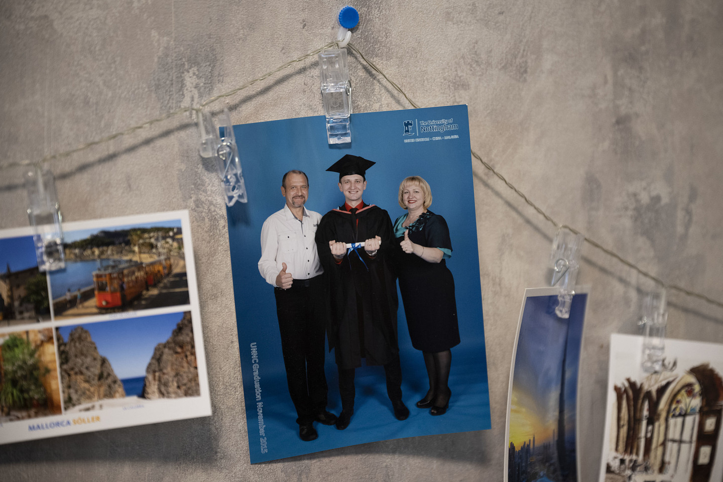 吉利在基辅的住处牆上，挂着毕业时与父母的合影。（摄影／杨子磊）
