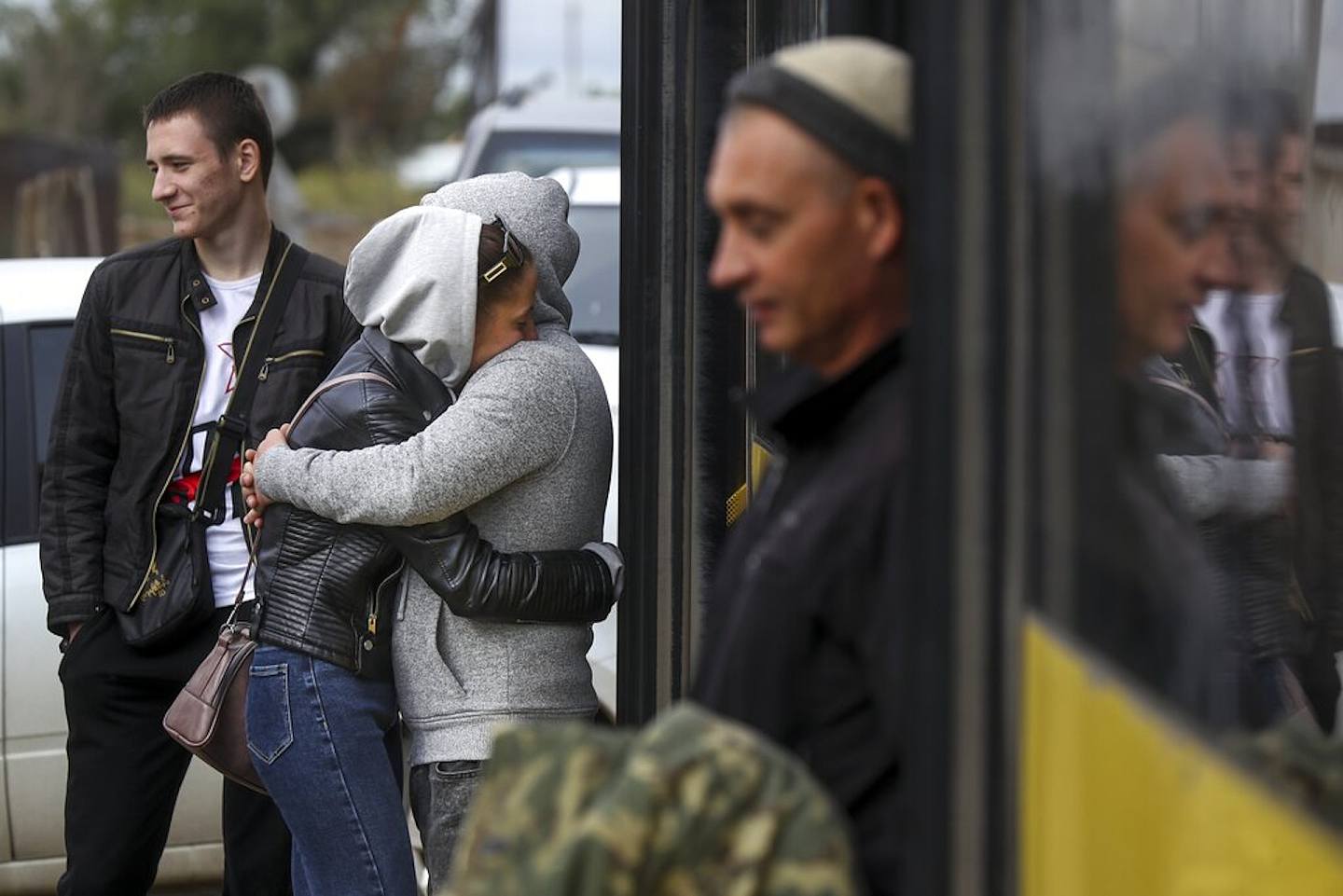 2022年9月24日準備入伍的俄羅斯新兵（背向鏡頭）在俄羅斯伏爾加格勒（Volgograd）一個軍事招募中心登上一輛巴士，臨行前與妻子擁抱及親吻。俄羅斯總統普京21日下令動員部份預備役人員，加強俄軍在烏克蘭的軍事行動。（AP）