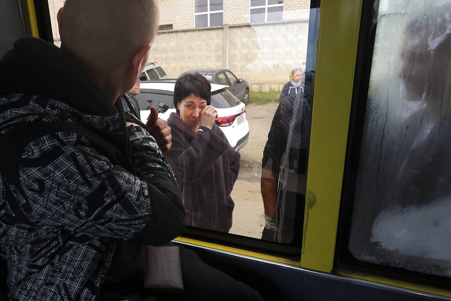 2022年9月24日準備入伍的俄羅斯新兵（背向鏡頭）在俄羅斯伏爾加格勒（Volgograd）一個軍事招募中心登上一輛巴士，他在看向車窗外的母親。俄羅斯總統普京21日下令動員部份預備役人員，加強俄軍在烏克蘭的軍事行動。（AP）