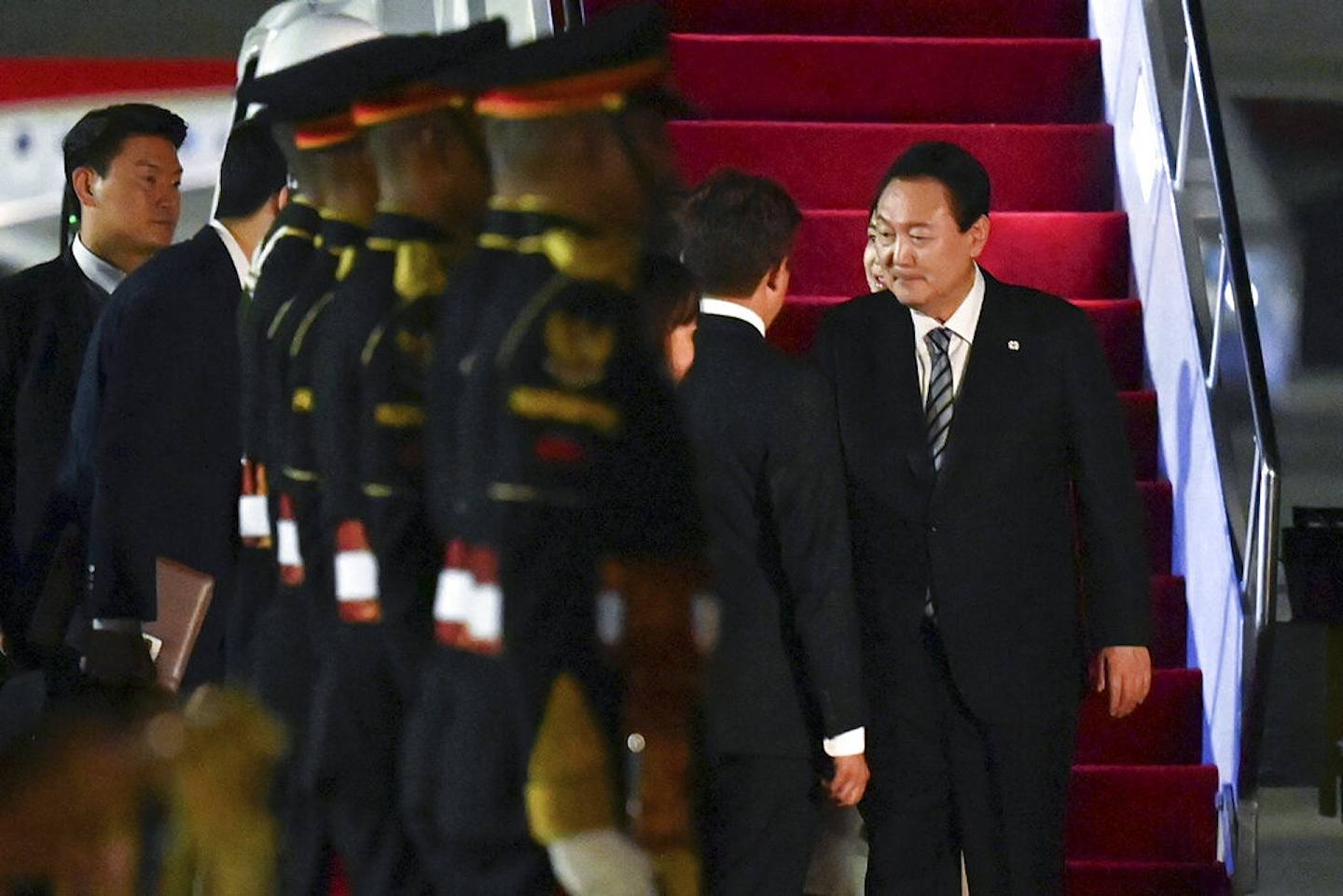 图为2022年11月13日韩国总统尹锡悦与晚上从柬埔寨金边飞抵印尼峇里岛，印尼官员在场迎接。 （AP）