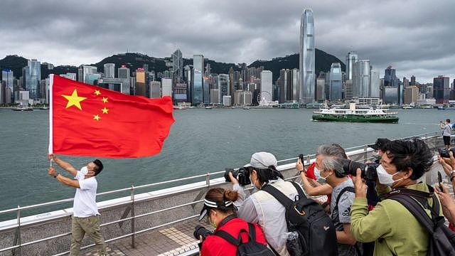 香港尖沙咀海旁一名男子挥舞中国国旗供他人拍照（1/7/2022）
