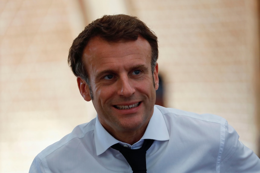 Emmanuel Macron looks to the left. 