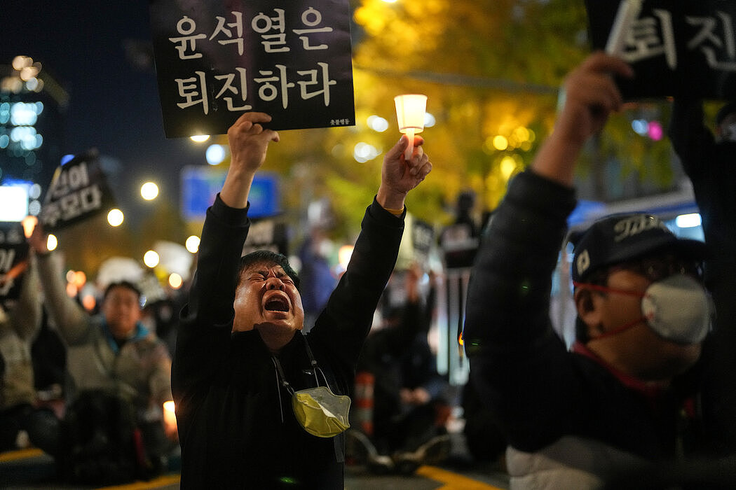 许多韩国人将梨泰院灾难的责任完全归咎于最高层。 上图是11月初一名男子在市政厅抗议时高举的标语，要求总统下台。