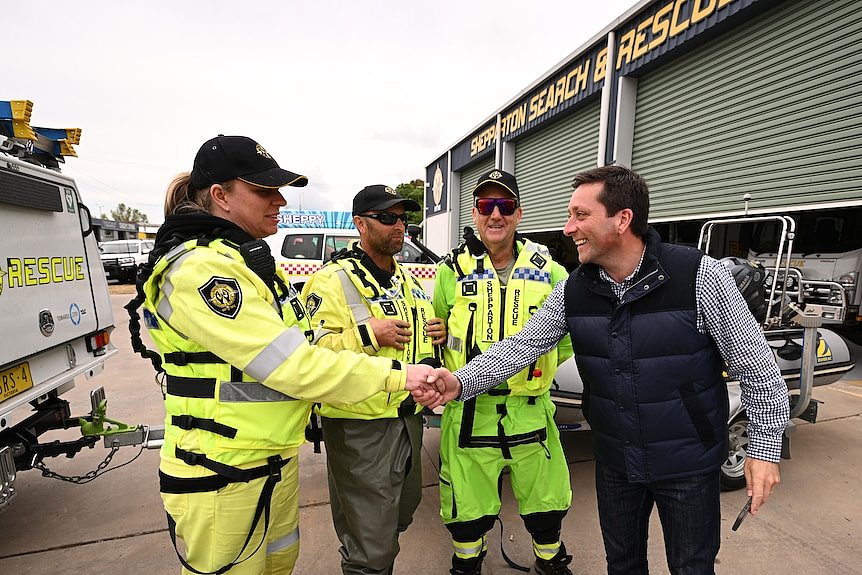 Matthew Guy smiles and shakes the hand of a man in hi-vis.