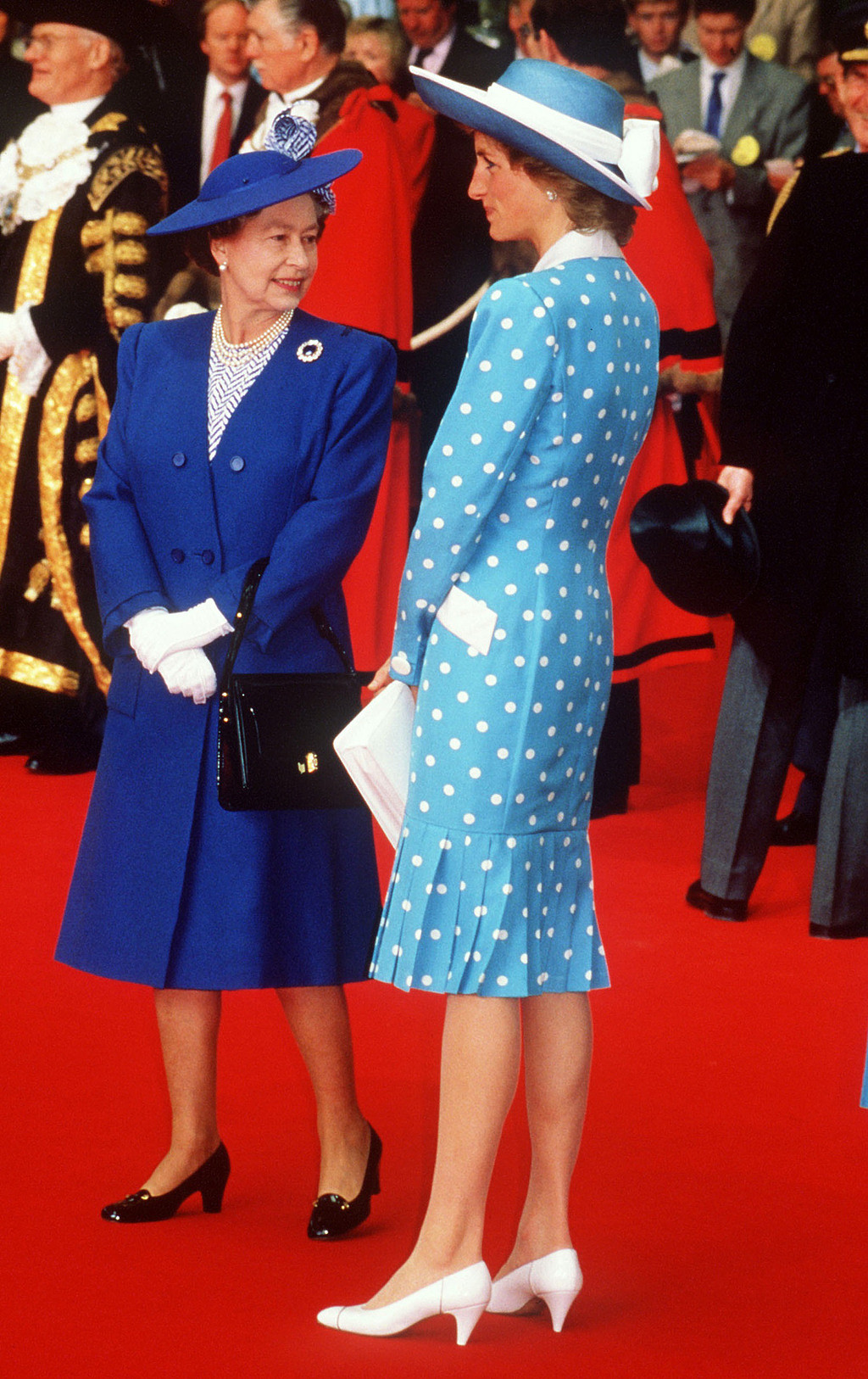 已故英國黛安娜王妃（Princess Diana）與查爾斯離婚前，衣著以保守洋裝為主。圖為1989年她與女王。（資料照／TPG、達志影像）