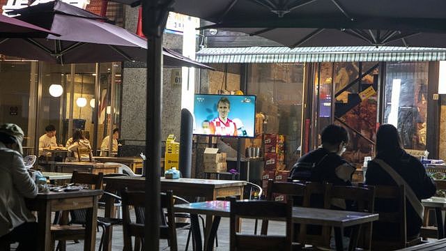 上海市民坐在几乎空无一人的酒吧里，看着克罗地亚足球运动员卢卡莫德里奇的屏幕