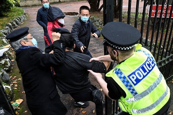 10月，在英国曼彻斯特的中国领事馆举行的一次示威活动中，一名英国警察对抗议者（中）和领事馆工作人员之间的肢体冲突进行了干预。