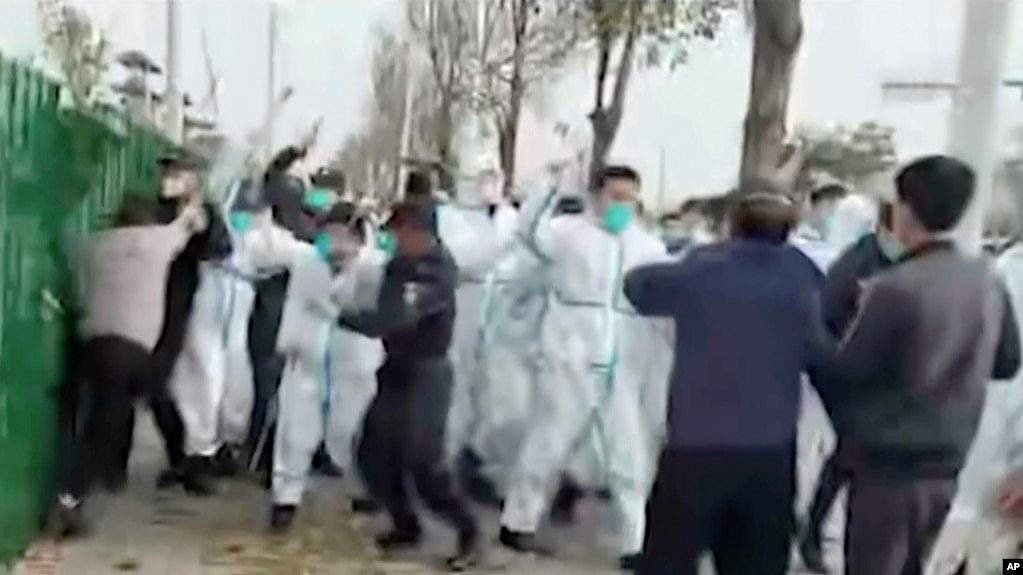 中国河南郑州富士康代工厂里身穿防护服的警察和保安殴打参加示威活动的工人。(2022年11月23日)
