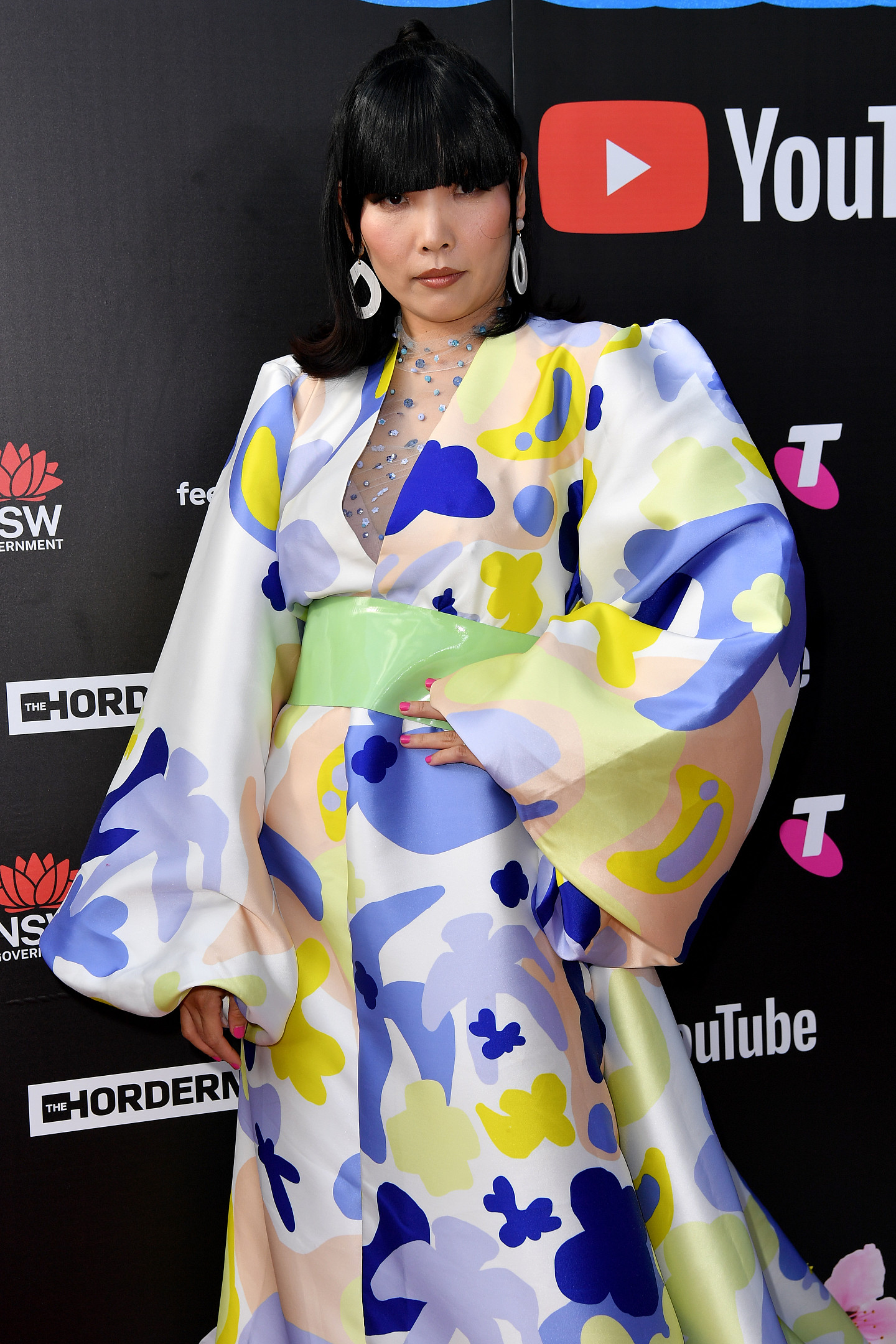 Dami Im wearing a long-sleeved dress with pastel purple, yellow and green splodges 