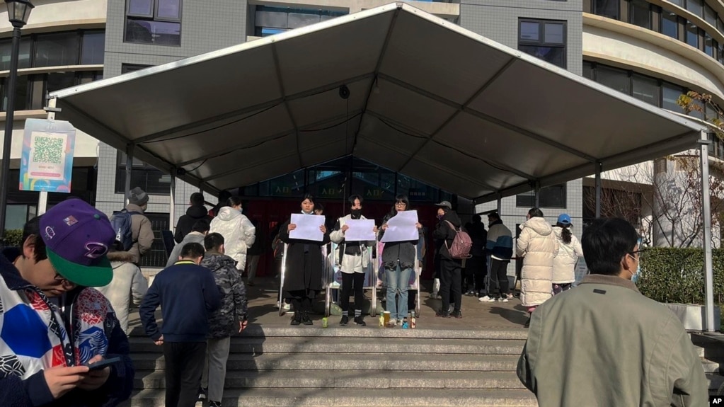 北京清华大学的学生手举白纸抗议严厉的防疫政策，悼念日前在新疆乌鲁木齐市死于火灾的至少10名遇难者 (022年11月27日)