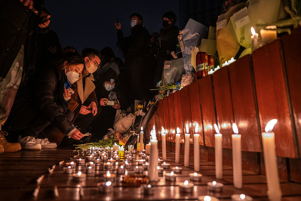 在北京的一个临时悼念处，人们点亮蜡烛。
