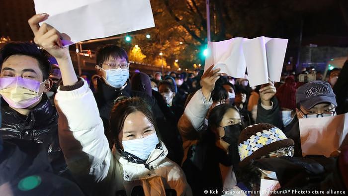 在北京亮马桥展示白纸的抗议民众