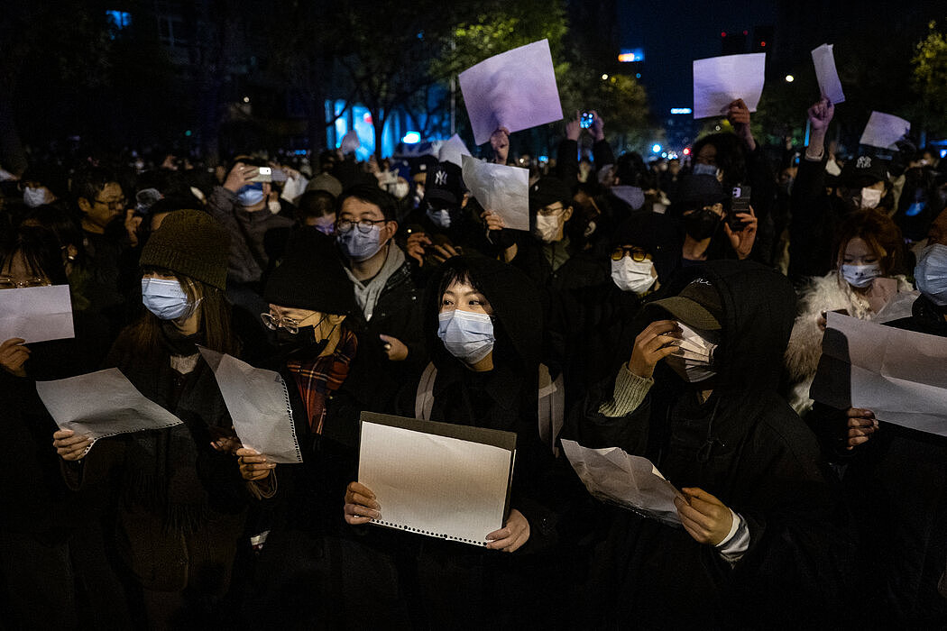 周日，抗议者在北京游行反对中国严苛的“清零”政策，他们手举白纸反抗审查制度。