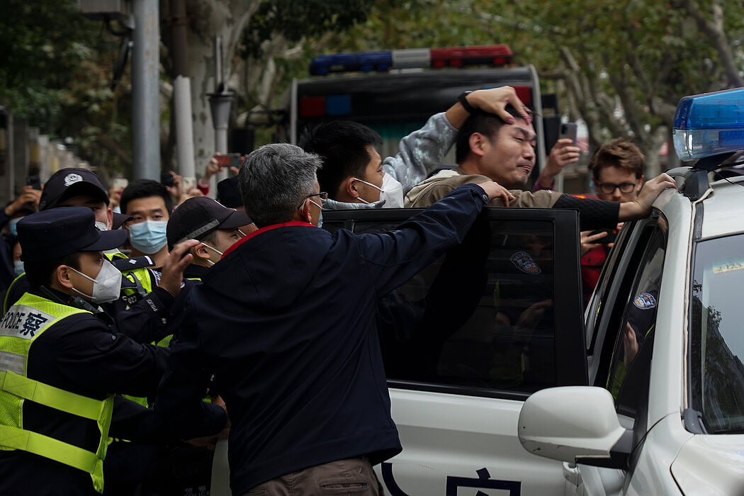 周日，在上海的一场抗议中，一名抗议者被押入警车。