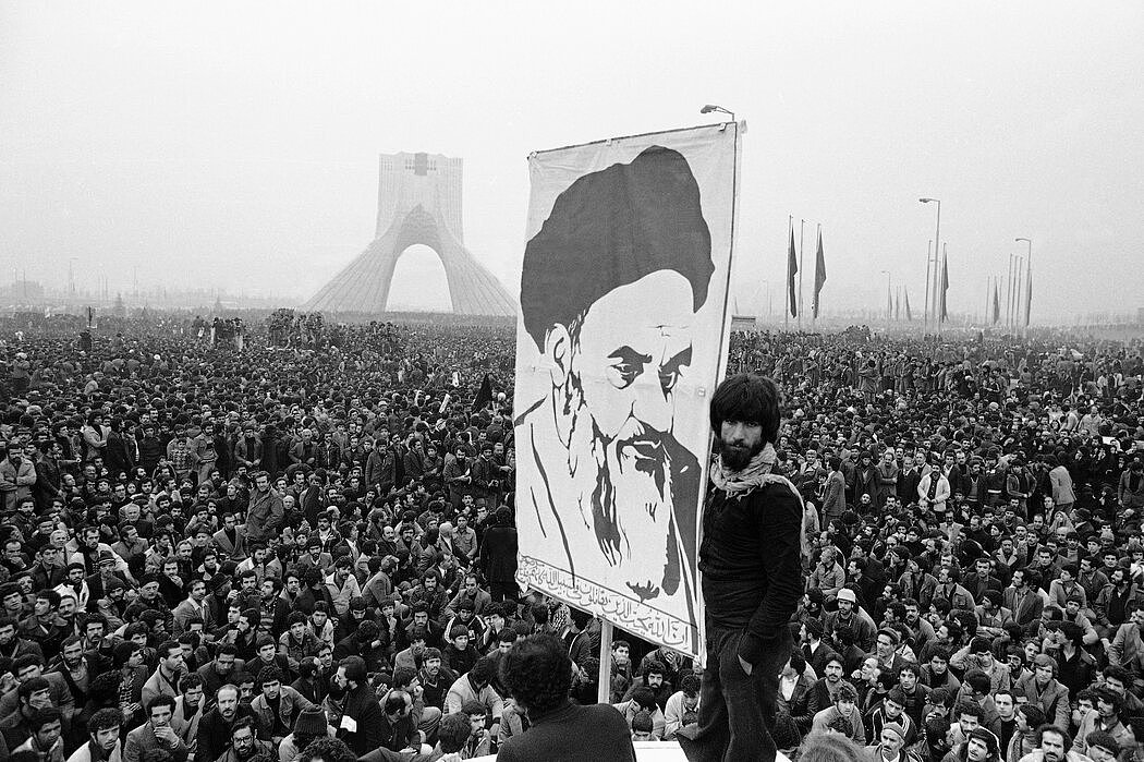 1978 年，在抗议伊朗国王期间，德黑兰的示威者高举当时流亡海外的鲁霍拉·霍梅尼的海报。