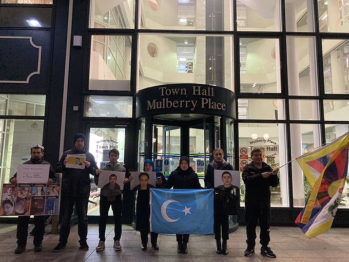 伦敦哈姆雷特塔自治市议会（Tower Hamlets Council）就中国驻英新大使馆规划方案举行讨论会议期间，在英维吾尔人和藏人在场外抗议。 （“停止维吾尔种族灭绝”（Stop Uyghur Genocide）组织推特截图）