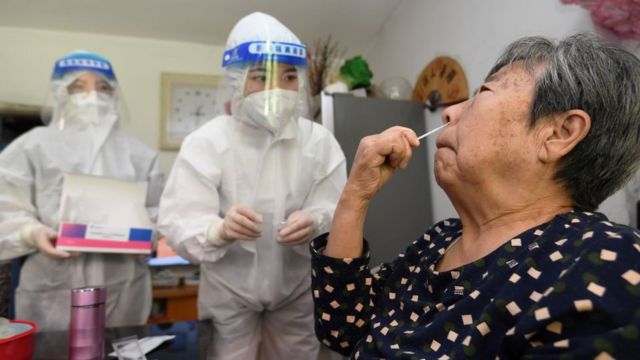 A staff member instructs elderly people on antigen testing at their home in Guiyang, Guizhou province, China, Sept 7, 2022.