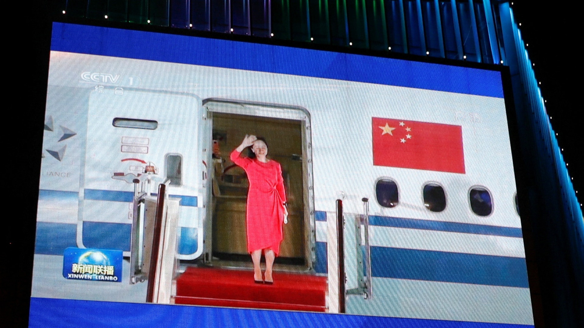 圖為2021年9月26日，中國北京一個商場的大型電視熒幕，播放華為副董事長兼首席財務官孟晚舟在加拿大獲釋後，乘飛機返抵中國的片段。（Reuters）