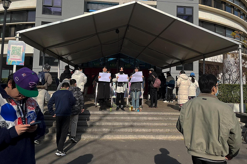 图为北京清华大学学生11月27日手持白纸表达诉求。（美联社）