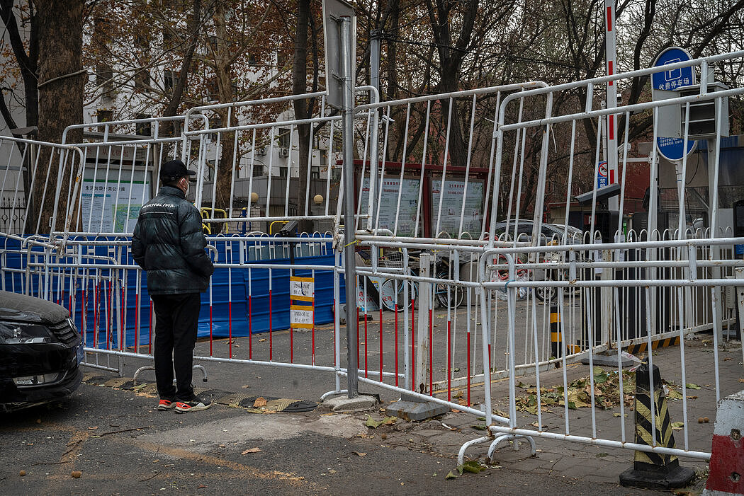 一名男子在北京一个被封小区的围栏外等待亲戚，摄于上周五。
