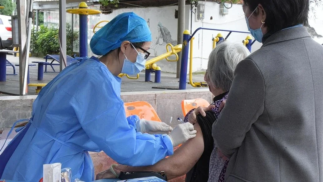 2022年12月1日，广东东莞，医护人员为老人接种新冠疫苗。视觉中国 图