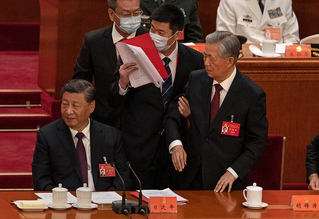 胡锦涛（右）在二十大上被工作人员带离主席台时，习近平把视线移开。