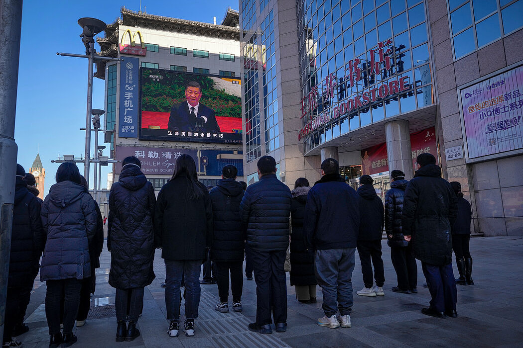 在北京一条购物街，民众观看大屏幕上播出的江泽民追悼会。