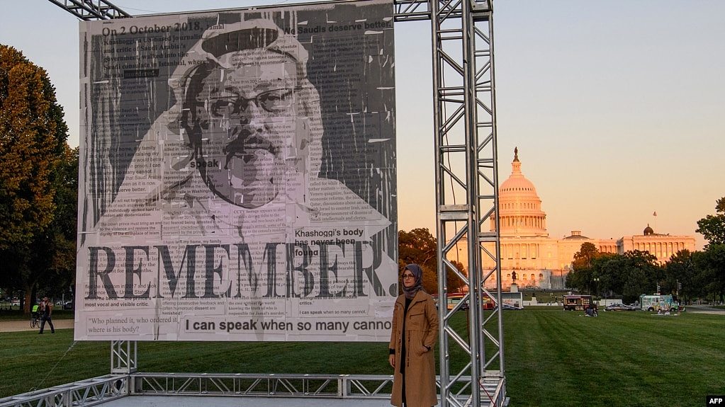 资料照片：土耳其作家简吉兹在华盛顿国会大草坪为纪念她的未婚夫、遇害沙特记者卡舒吉的画像揭幕后与画像合影。(2021年10月1日)