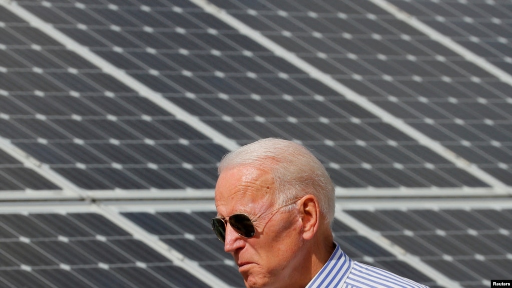 资料图片：民主党 2020 年美国总统候选人拜登走过位于普利茅斯市的太阳能电池板