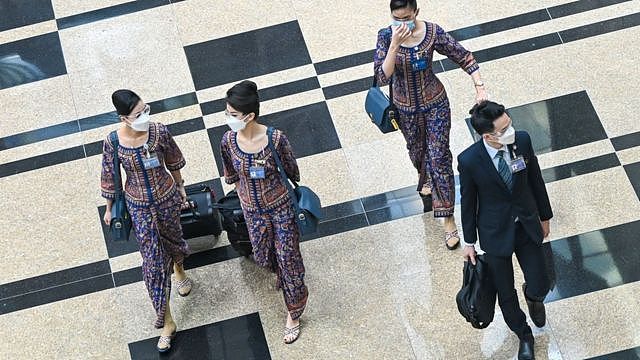 新加坡樟宜机场内一群新加坡航空机组人员走过转机大厅（12/1/2022）