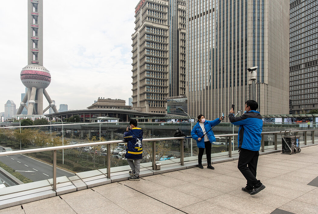 上海陆家嘴金融区的过街天桥。 政府周三宣布了减少限制国内城市间人员流动的新政策，这可能会推动消费，但也会让疾病传播。