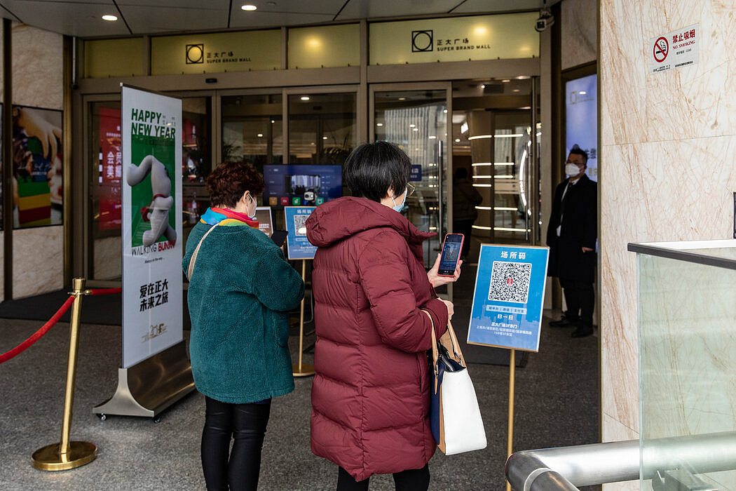 在进入上海陆家嘴金融区的一家商场前，消费者正在扫健康码。
