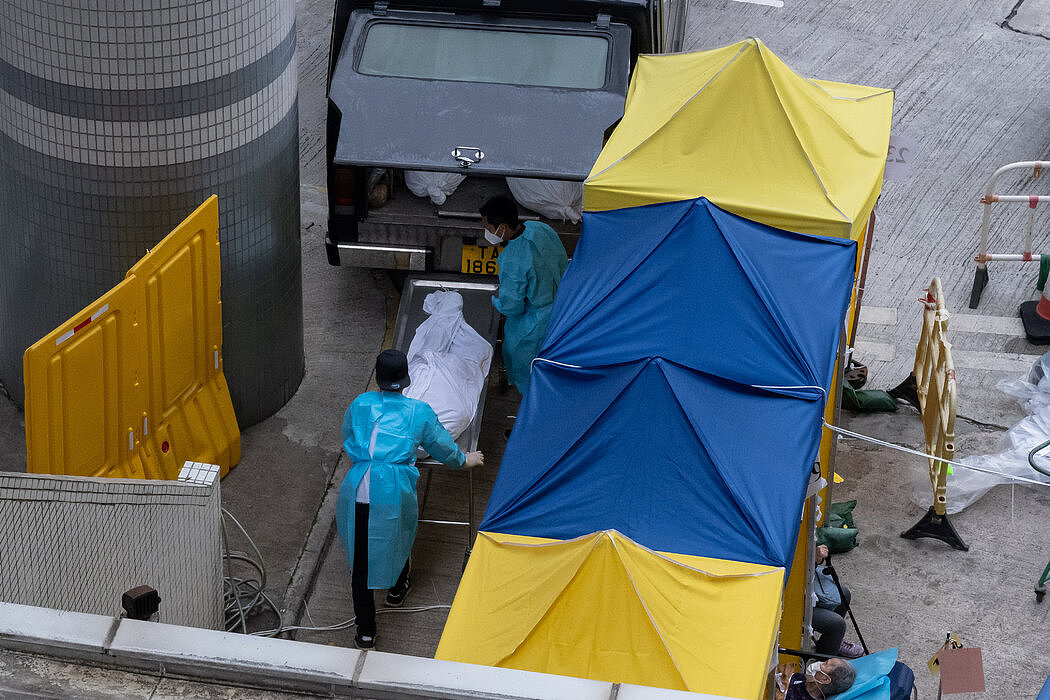 殡仪馆工人在香港一家医院外将尸体装上车，摄于今年3月。