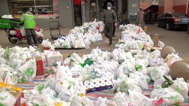 北京一家商店外的地上堆满了杂货，等待送货员。