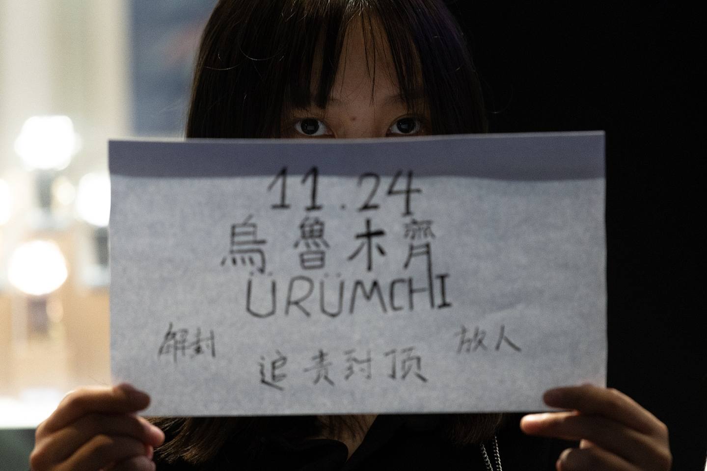 「白纸运动」蔓延至香港，约40名市民11月28日晚上响应号召到中环戏院里参加烛光悼念集会，部份人拿起白纸，一同悼念新疆乌鲁木齐大火的死难者。 （梁鹏威摄）