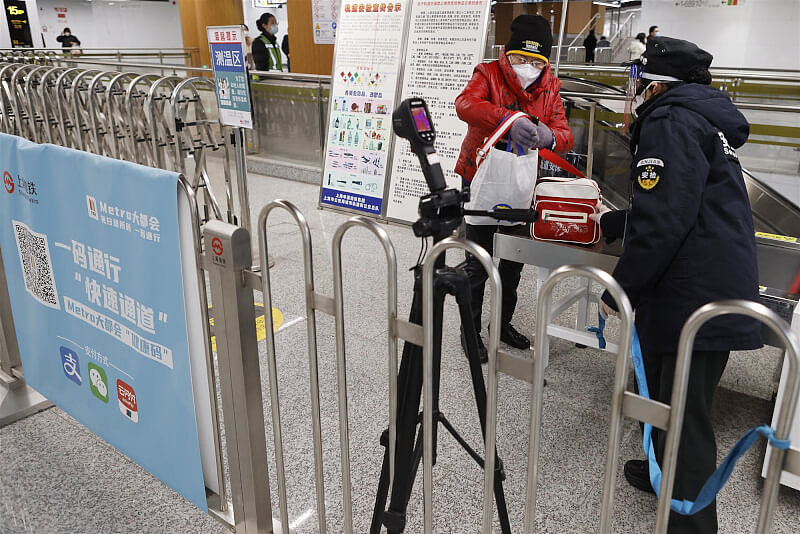 上海13日零时起除了特殊场所外不再扫码查码，防疫措施短短几天内不断放宽，民众直呼「太魔幻了」。 图为13日上海地铁乘客进站安检。 （中新社）