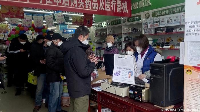图为12月14日北京的一家药店，人们正在排队买药
