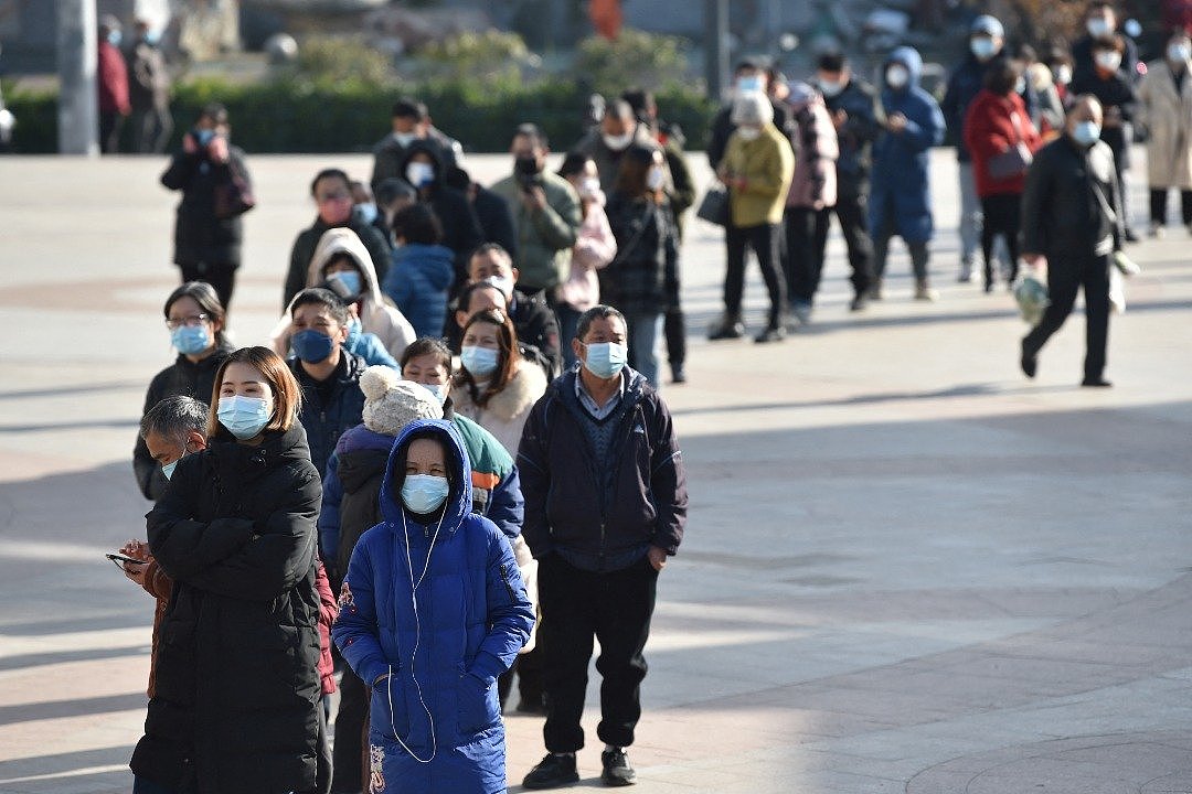 中国江苏南京市民周四在药店外排队，购买抗原检测试剂盒。（图取自路透社）