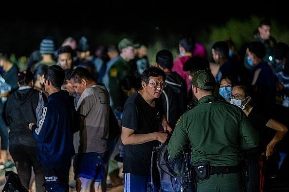 今年5月，一些中国移民穿越格兰河偷渡进入美国之后，在德州的罗马市和美国边防人员沟通。（摄影／Brandon Bell／Getty Images
