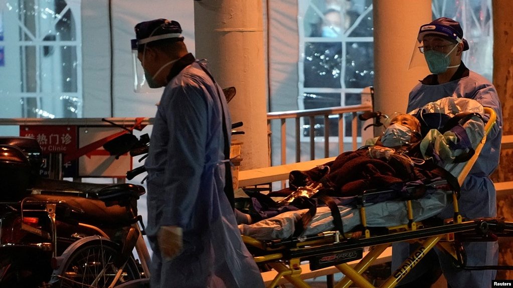 上海医护人员在运送一名病人进入医院的发热门诊。（2022年12月19日）