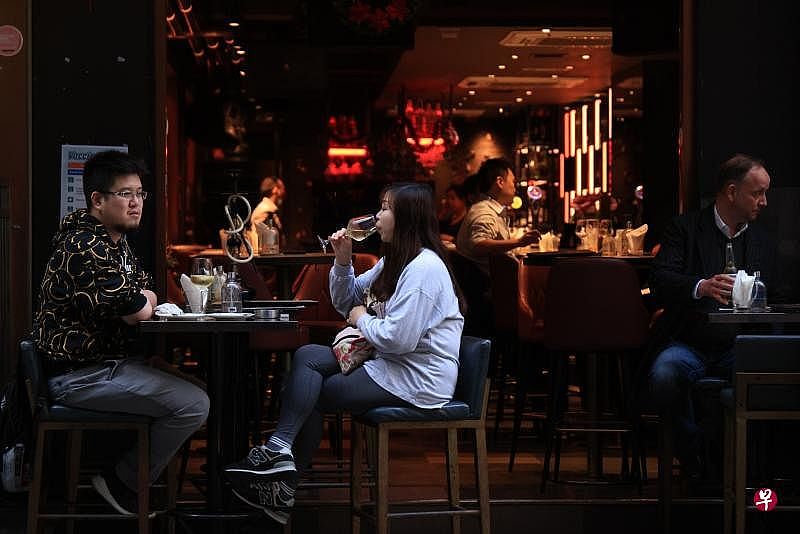 香港特区政府12月20日公布最新防疫安排，包括撤销酒吧、夜店、参与宴会人士、参加当地游旅客的快速抗原测试要求。图为香港市民于酒吧休闲。（香港中通社）